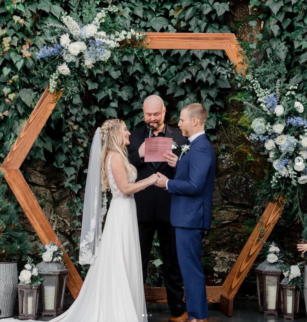 Outdoor wedding ceremony under a wooden hexagon arch in the courtyard at Stone House Nevada City