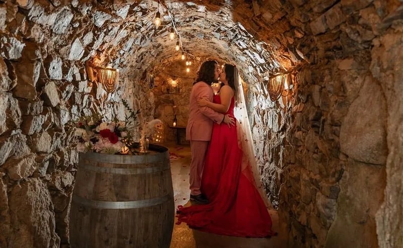 Wedding couple portrait in The Cavern at Stone House Nevada City — candlelit underground stone arches