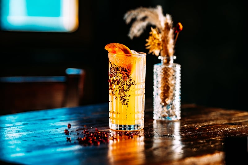 Orange signature cocktail garnished with pampas at a Stone House Nevada City private event